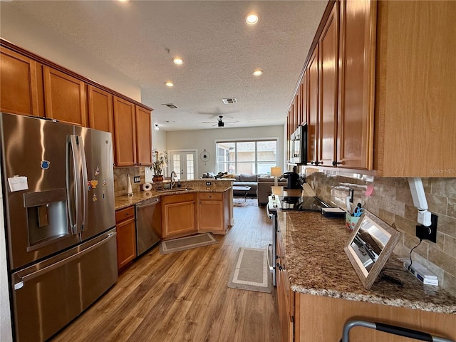 2287 Park Maitland Ct, Maitland, FL 32751 - kitchen with a sink, a peninsula, stainless steel appliances, wood finished floors, and open floor plan