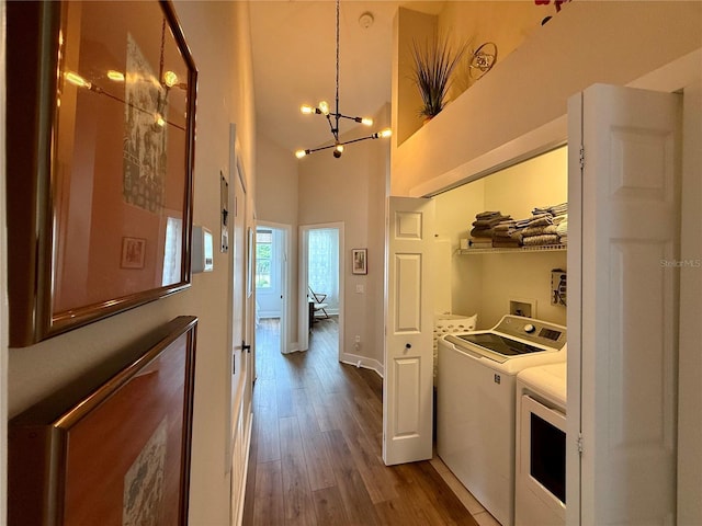 2287 Park Maitland Ct, Maitland, FL 32751 - laundry room featuring washer and clothes dryer, wood finished floors, laundry area, a high ceiling, and a notable chandelier