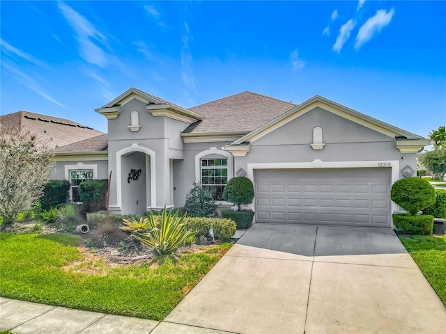 12313 Prairie Plantation Way, Orlando, FL 32824 - view of front of property with roof with shingles, stucco siding, an attached garage, and driveway