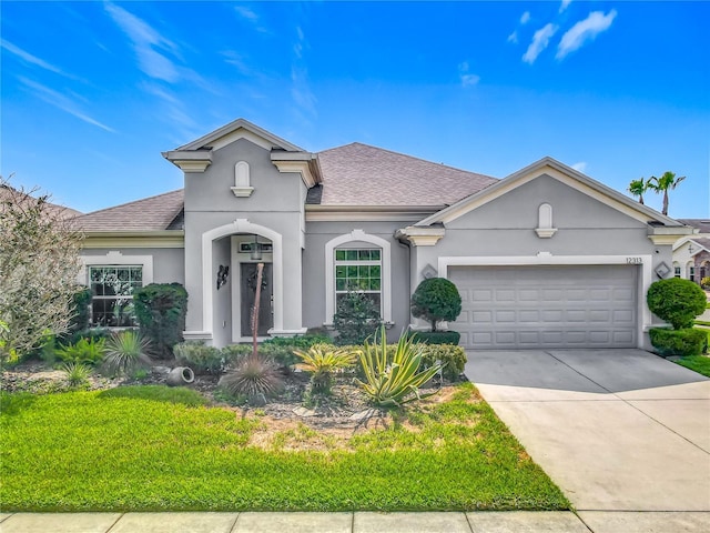 12313 Prairie Plantation Way, Orlando, FL 32824 - view of front facade featuring stucco siding, a shingled roof, an attached garage, concrete driveway, and a front lawn