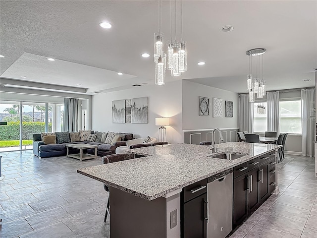 12313 Prairie Plantation Way, Orlando, FL 32824 - kitchen featuring a sink, stainless steel dishwasher, a chandelier, an island with sink, and open floor plan