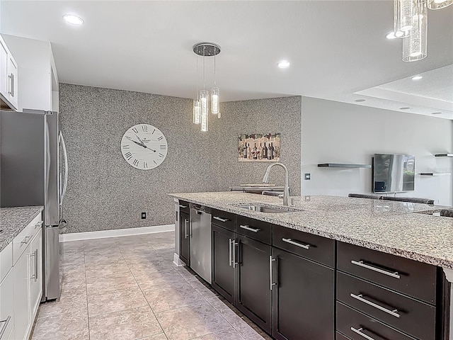 12313 Prairie Plantation Way, Orlando, FL 32824 - kitchen with a sink, stainless steel appliances, white cabinetry, pendant lighting, and light stone counters