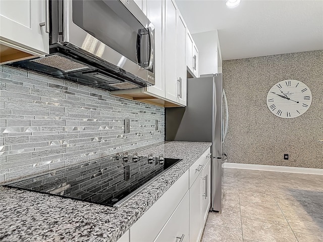 12313 Prairie Plantation Way, Orlando, FL 32824 - kitchen featuring white cabinets, light stone countertops, stainless steel appliances, and decorative backsplash