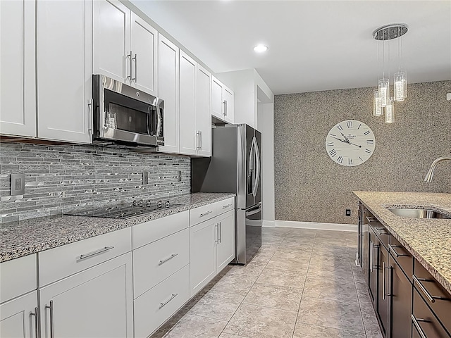 12313 Prairie Plantation Way, Orlando, FL 32824 - kitchen featuring appliances with stainless steel finishes, a sink, light stone countertops, decorative light fixtures, and white cabinets