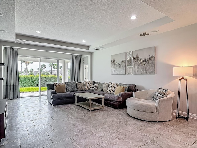 12313 Prairie Plantation Way, Orlando, FL 32824 - living room with a textured ceiling, a tray ceiling, and recessed lighting