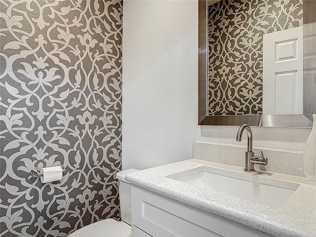 12313 Prairie Plantation Way, Orlando, FL 32824 - bathroom with wallpapered walls, toilet, and vanity