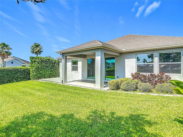 12313 Prairie Plantation Way, Orlando, FL 32824 - rear view of house featuring a patio area, stucco siding, a lawn, and a shingled roof