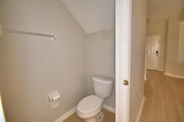 3151 Sinclair St Unit 104, Orlando, FL 32835 - bathroom with lofted ceiling, toilet, wood finished floors, and baseboards