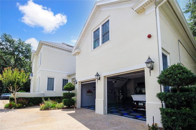 202 Acadia Ter, Kissimmee, FL 34747 - view of property exterior featuring a garage, stucco siding, and driveway