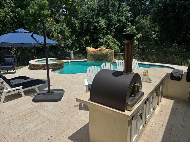 202 Acadia Ter, Kissimmee, FL 34747 - view of pool featuring area for grilling, fence, a patio, a pool with connected hot tub, and view of wooded area