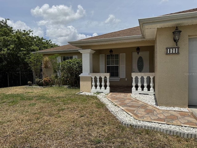 829 Anza Ave, Lehigh Acres, FL 33971 - entrance to property with covered porch, stucco siding, fence, and a yard