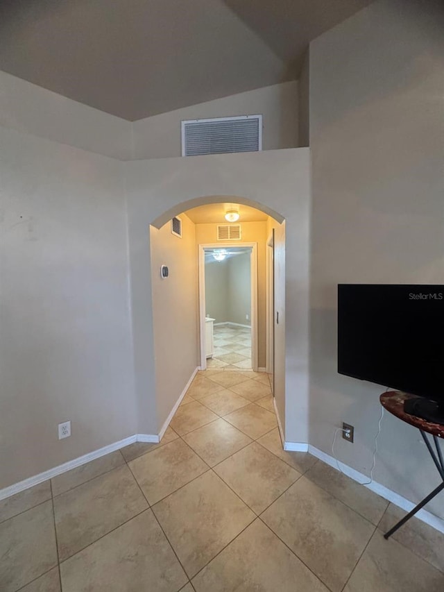 829 Anza Ave, Lehigh Acres, FL 33971 - hallway with high vaulted ceiling, visible vents, tile patterned flooring, baseboards, and arched walkways