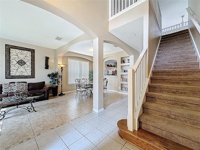 219 Rosso Dr, Davenport, FL 33837 - stairway with arched walkways, tile patterned flooring, built in features, and baseboards