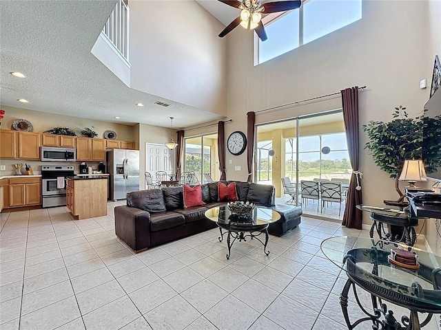 219 Rosso Dr, Davenport, FL 33837 - living area with light tile patterned floors, ceiling fan, a high ceiling, recessed lighting, and a textured ceiling