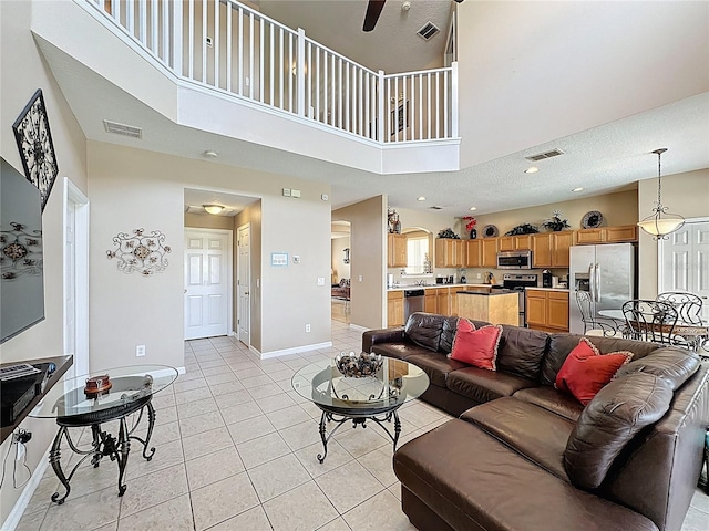 219 Rosso Dr, Davenport, FL 33837 - living area featuring light tile patterned flooring, baseboards, ceiling fan, a towering ceiling, and recessed lighting