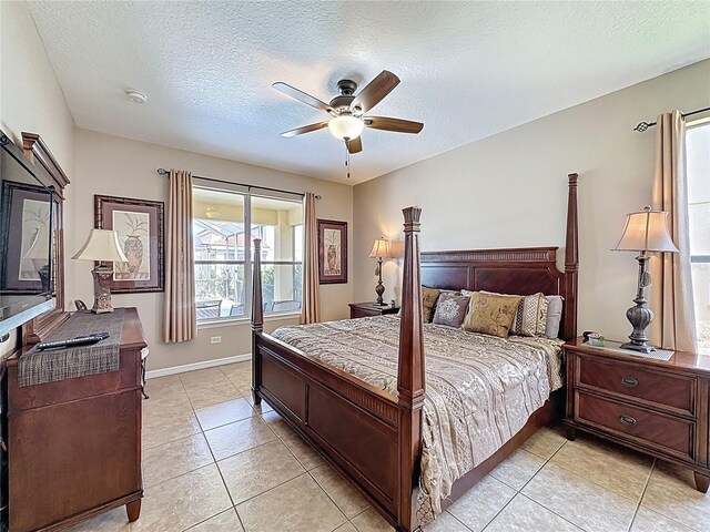 219 Rosso Dr, Davenport, FL 33837 - bedroom featuring a textured ceiling, light tile patterned floors, baseboards, and ceiling fan