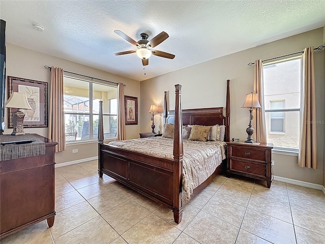 219 Rosso Dr, Davenport, FL 33837 - bedroom featuring light tile patterned floors, baseboards, a textured ceiling, and a ceiling fan