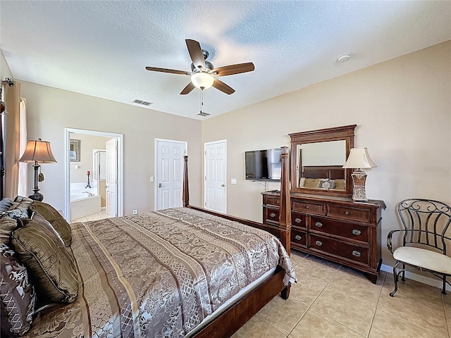 219 Rosso Dr, Davenport, FL 33837 - bedroom with light tile patterned floors, a ceiling fan, baseboards, ensuite bath, and a textured ceiling