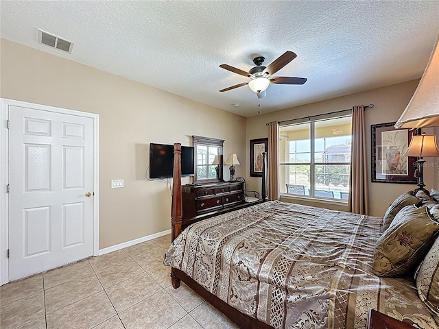 219 Rosso Dr, Davenport, FL 33837 - bedroom featuring light tile patterned flooring, a textured ceiling, a ceiling fan, and baseboards