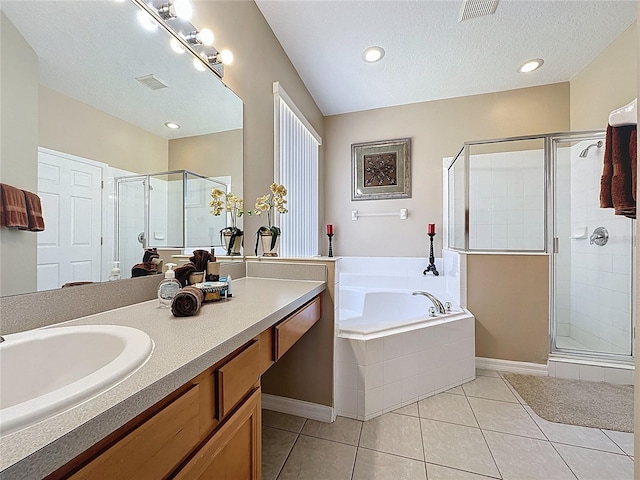 219 Rosso Dr, Davenport, FL 33837 - bathroom featuring a shower stall, a garden tub, tile patterned flooring, a textured ceiling, and vanity