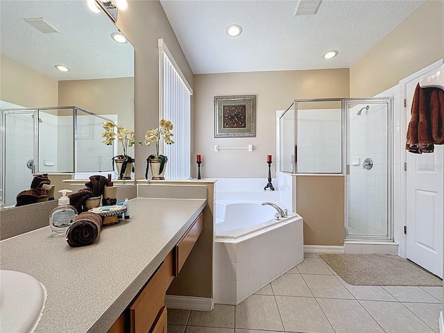 219 Rosso Dr, Davenport, FL 33837 - bathroom with a textured ceiling, a shower stall, tile patterned floors, a garden tub, and vanity