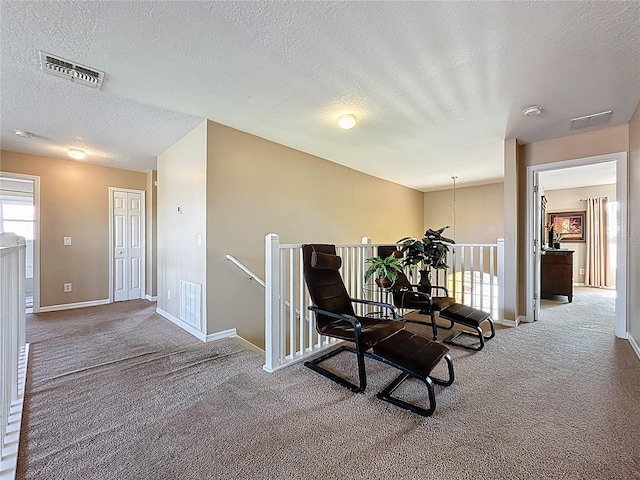 219 Rosso Dr, Davenport, FL 33837 - living area featuring an upstairs landing, carpet floors, a textured ceiling, and baseboards