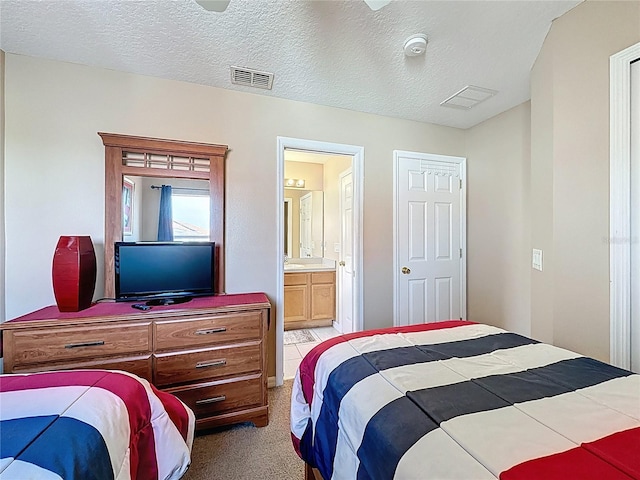 219 Rosso Dr, Davenport, FL 33837 - bedroom with light colored carpet, ensuite bathroom, and a textured ceiling