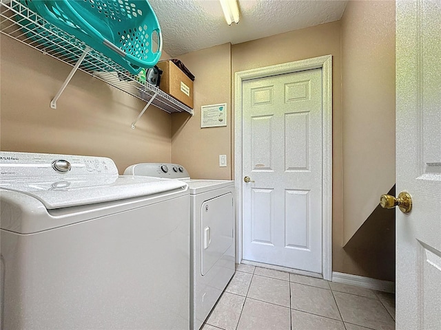 219 Rosso Dr, Davenport, FL 33837 - clothes washing area featuring washing machine and clothes dryer, light tile patterned flooring, and a textured ceiling