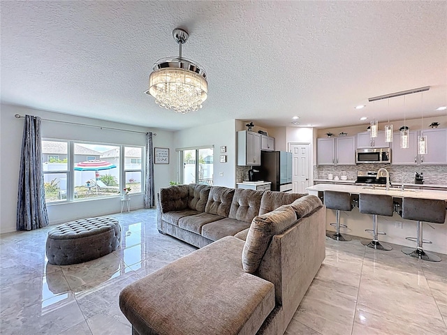 1181 Lone Palm Way, Saint Cloud, FL 34771 - living room featuring a textured ceiling, a chandelier, light marble finish floors, and recessed lighting