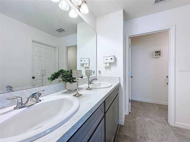 1181 Lone Palm Way, Saint Cloud, FL 34771 - bathroom featuring baseboards, double vanity, tile patterned flooring, and a textured ceiling