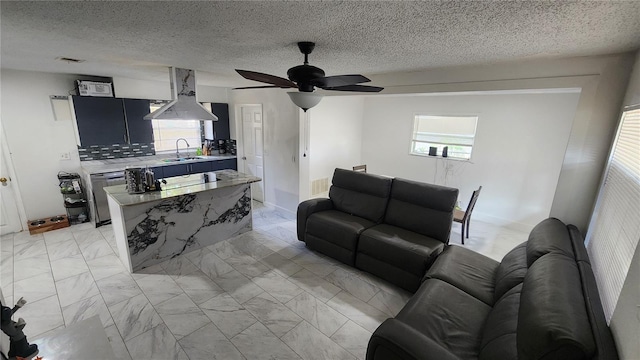 living room with light marble finish flooring, a ceiling fan, healthy amount of natural light, and a textured ceiling