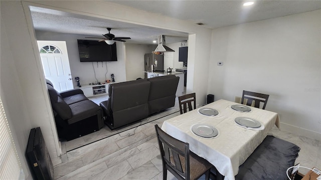 dining area featuring light marble finish flooring, ceiling fan, and baseboards