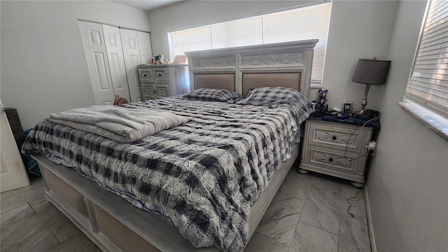 bedroom featuring a closet and marble finish flooring