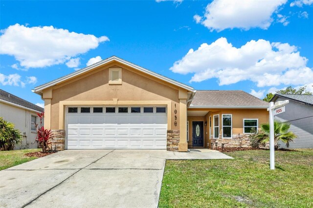 1050 Dees Dr, Oviedo, FL 32765 - ranch-style home featuring stone siding, stucco siding, concrete driveway, a front lawn, and a garage