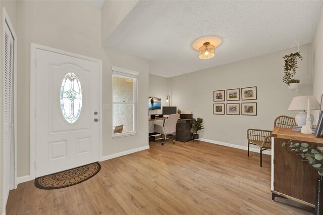 1050 Dees Dr, Oviedo, FL 32765 - entryway with light wood-type flooring, baseboards, and a textured ceiling