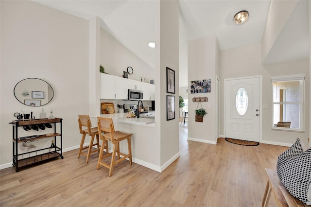 1050 Dees Dr, Oviedo, FL 32765 - foyer with high vaulted ceiling, light wood-style flooring, and baseboards