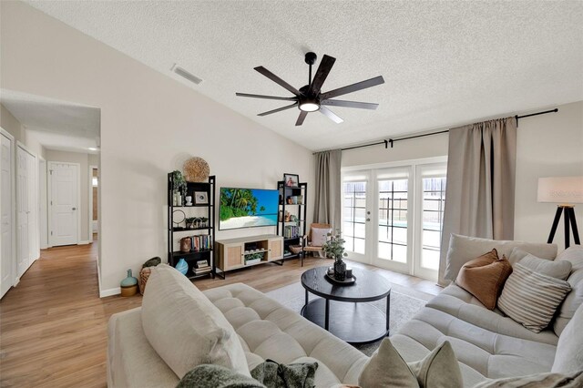 1050 Dees Dr, Oviedo, FL 32765 - living room featuring vaulted ceiling, ceiling fan, a textured ceiling, and light wood-style floors