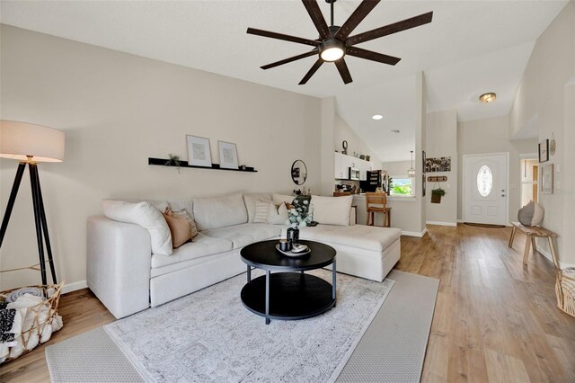 1050 Dees Dr, Oviedo, FL 32765 - living room featuring ceiling fan, vaulted ceiling, light wood-style flooring, and baseboards