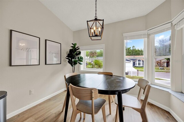 1050 Dees Dr, Oviedo, FL 32765 - dining space with light wood finished floors, a chandelier, baseboards, and a textured ceiling