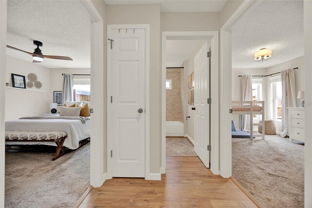 1050 Dees Dr, Oviedo, FL 32765 - hall featuring light colored carpet, a textured ceiling, light wood finished floors, and baseboards