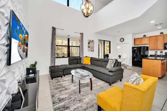 living room with light tile patterned floors, an inviting chandelier, visible vents, and a high ceiling