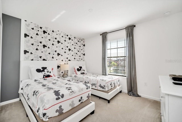 bedroom with light colored carpet and baseboards