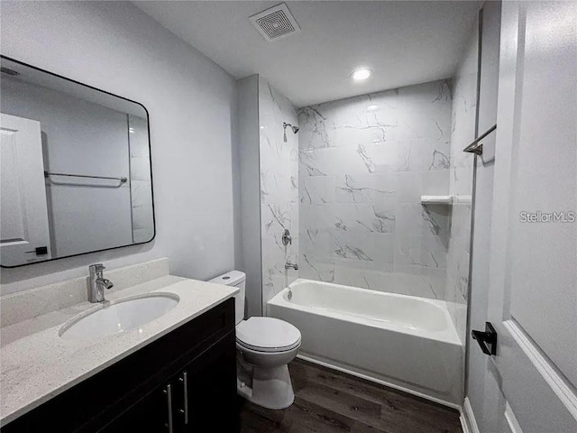 full bath with wood finished floors, toilet, vanity, and washtub / shower combination