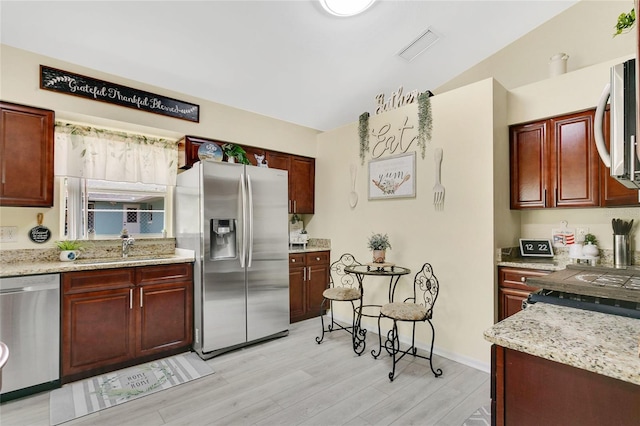 906 Elm Forest Dr, Minneola, FL 34715 - kitchen featuring stainless steel appliances, a sink, light wood-style flooring, and reddish brown cabinets