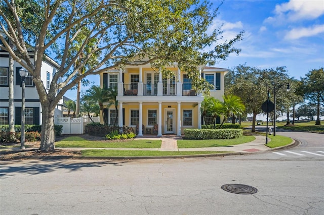 7550 Gathering Dr, Reunion, FL 34747 - greek revival inspired property featuring a balcony, a porch, and stucco siding