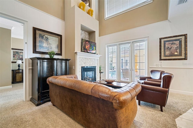 7550 Gathering Dr, Reunion, FL 34747 - carpeted living room featuring plenty of natural light, a fireplace, a towering ceiling, and wainscoting