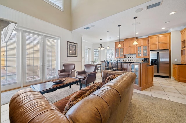 7550 Gathering Dr, Reunion, FL 34747 - living room with light tile patterned floors, light carpet, a chandelier, recessed lighting, and a high ceiling
