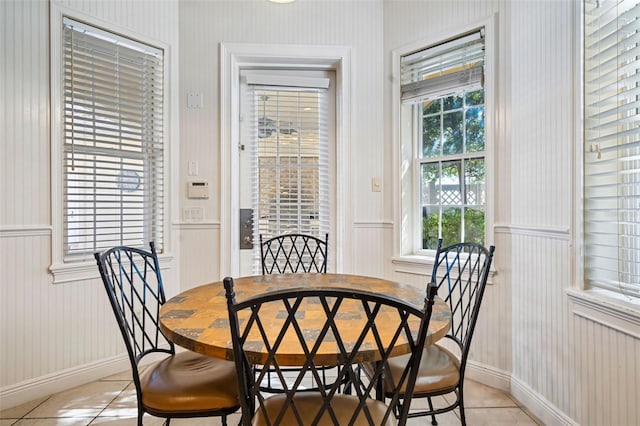 7550 Gathering Dr, Reunion, FL 34747 - dining room with light tile patterned flooring, a wainscoted wall, wallpapered walls, baseboards, and a decorative wall