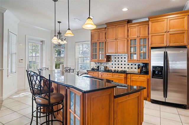 7550 Gathering Dr, Reunion, FL 34747 - kitchen with stainless steel refrigerator with ice dispenser, brown cabinets, dark countertops, ornamental molding, and a sink