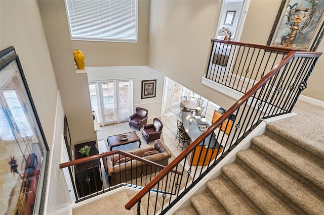 7550 Gathering Dr, Reunion, FL 34747 - stairs with a towering ceiling, carpet flooring, and baseboards